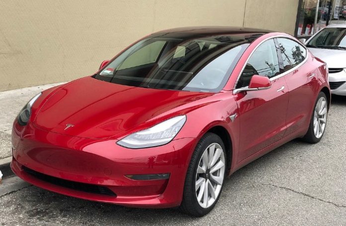 Red Tesla Model 3 Parked On Street